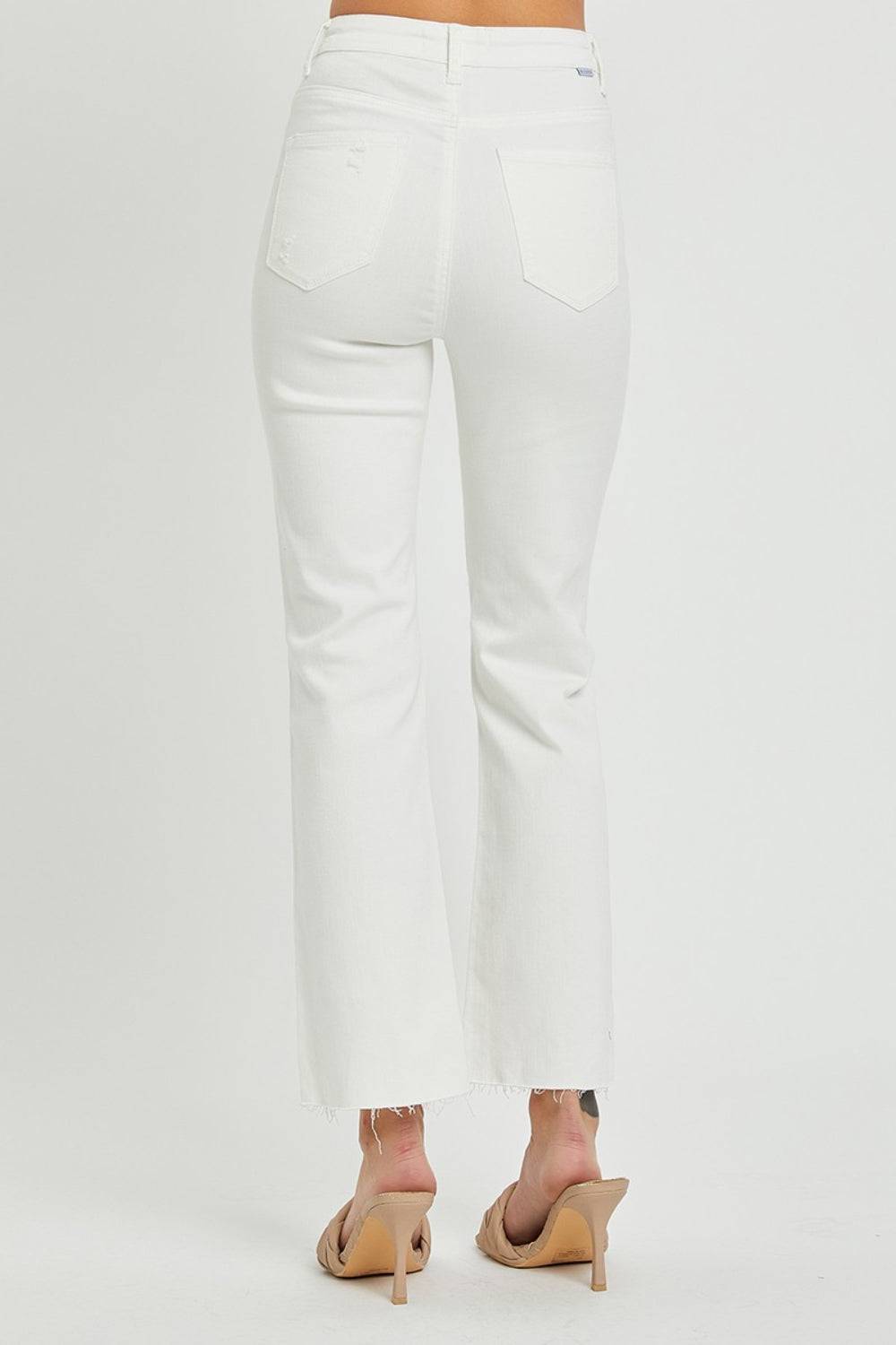 a woman is wearing white jeans and heels