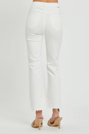 a woman is wearing white jeans and heels