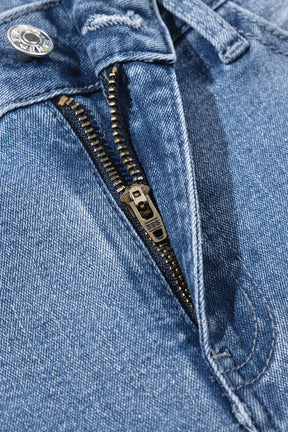 Close-up of zipper on raw hem wide leg jeans.