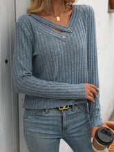 Blue ribbed V-neck long sleeve T-shirt with buttons.