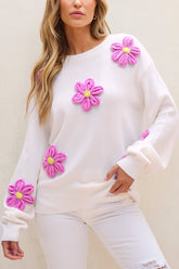 White sweater with pink crochet flowers, round neck, long sleeves.