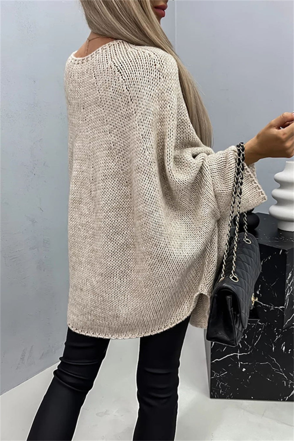 Back view of beige batwing sleeve sweater, elegant design.