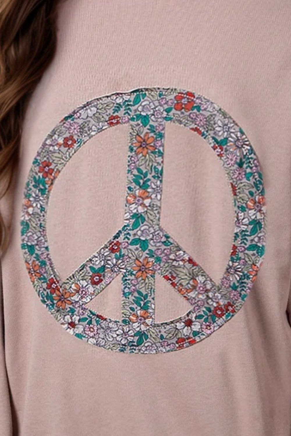 Close-up of floral peace sign applique on sweatshirt