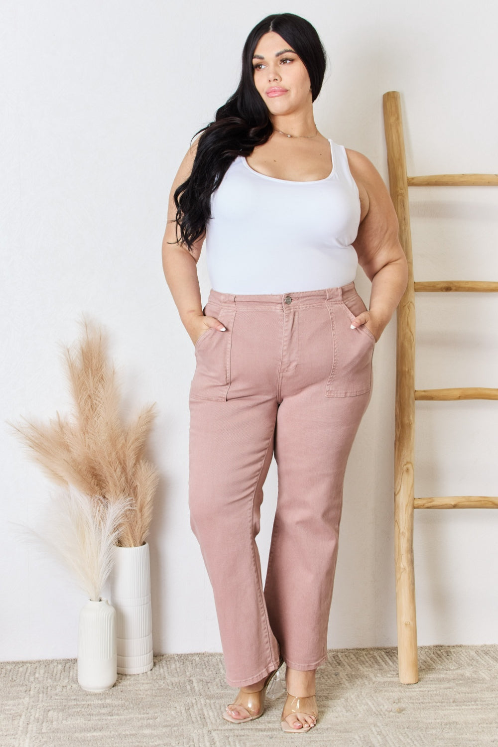 Model wearing RISEN high rise ankle flare jeans in pink.