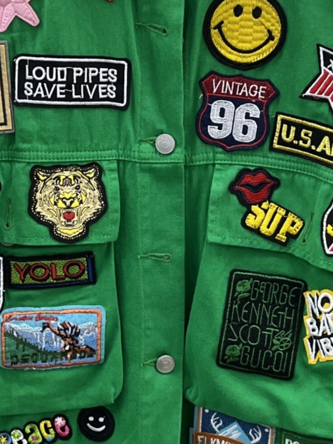 Close-up of patches on green jacket.