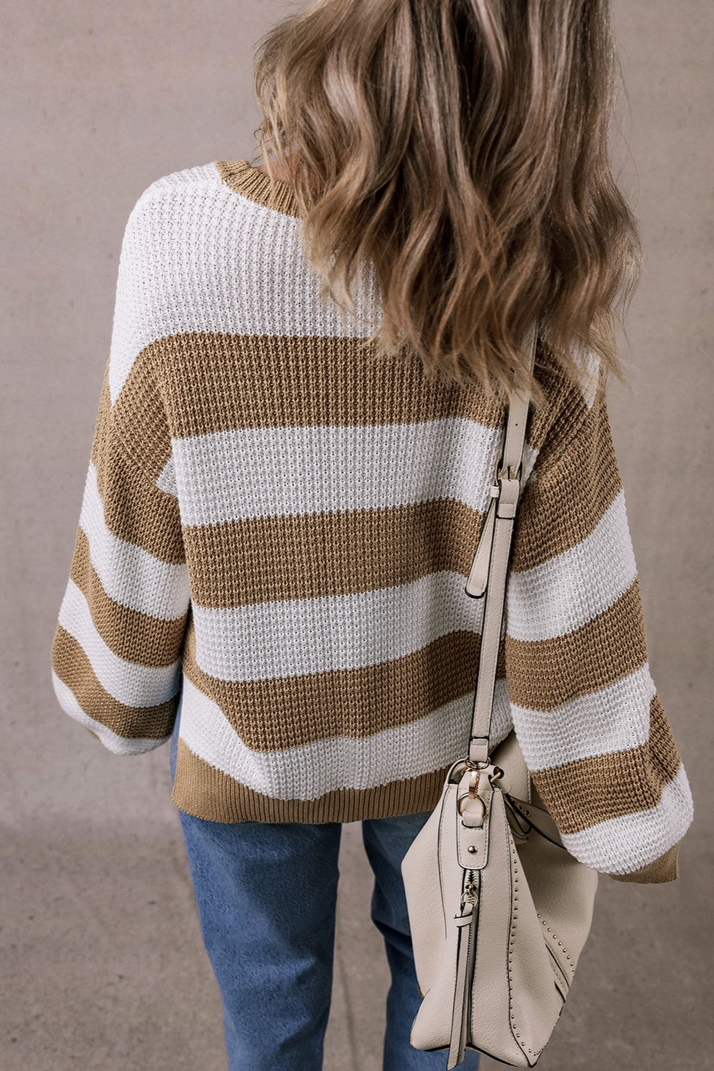 Color block round neck sweater with brown and white stripes, back view.