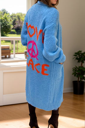 a woman standing in a room wearing a blue sweater