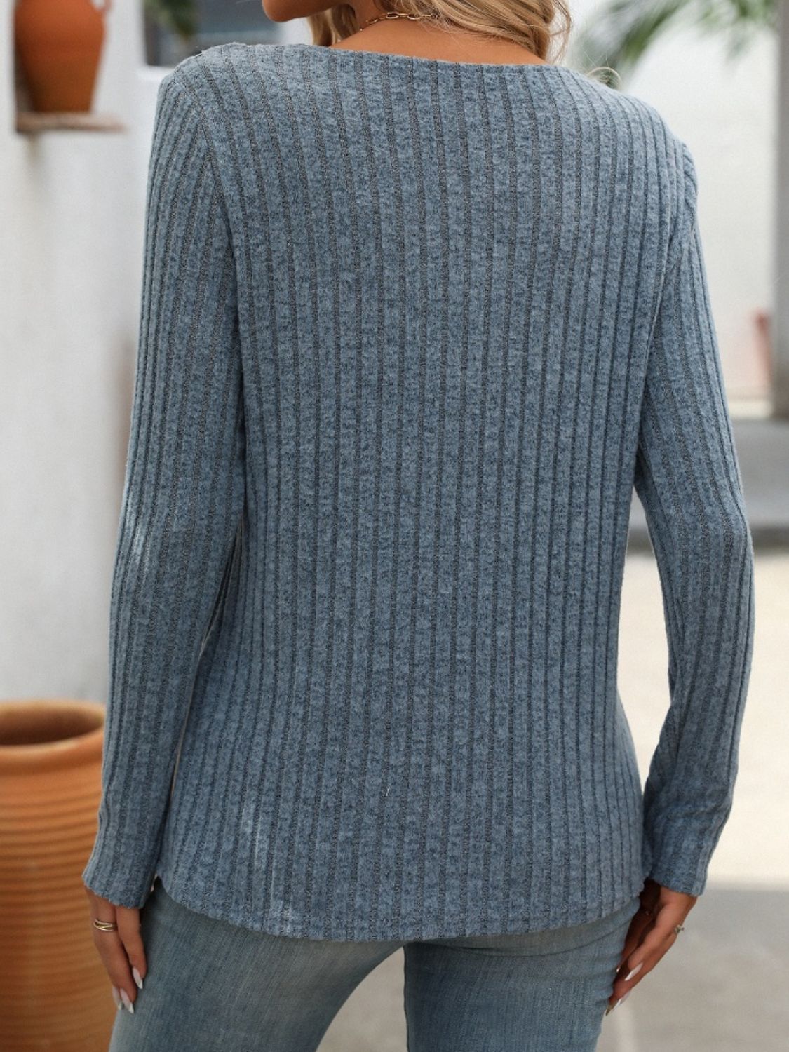 Back view of blue ribbed V-neck long sleeve T-shirt.