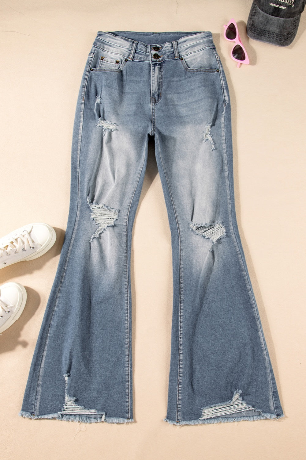 Flat lay of distressed raw hem wide leg jeans