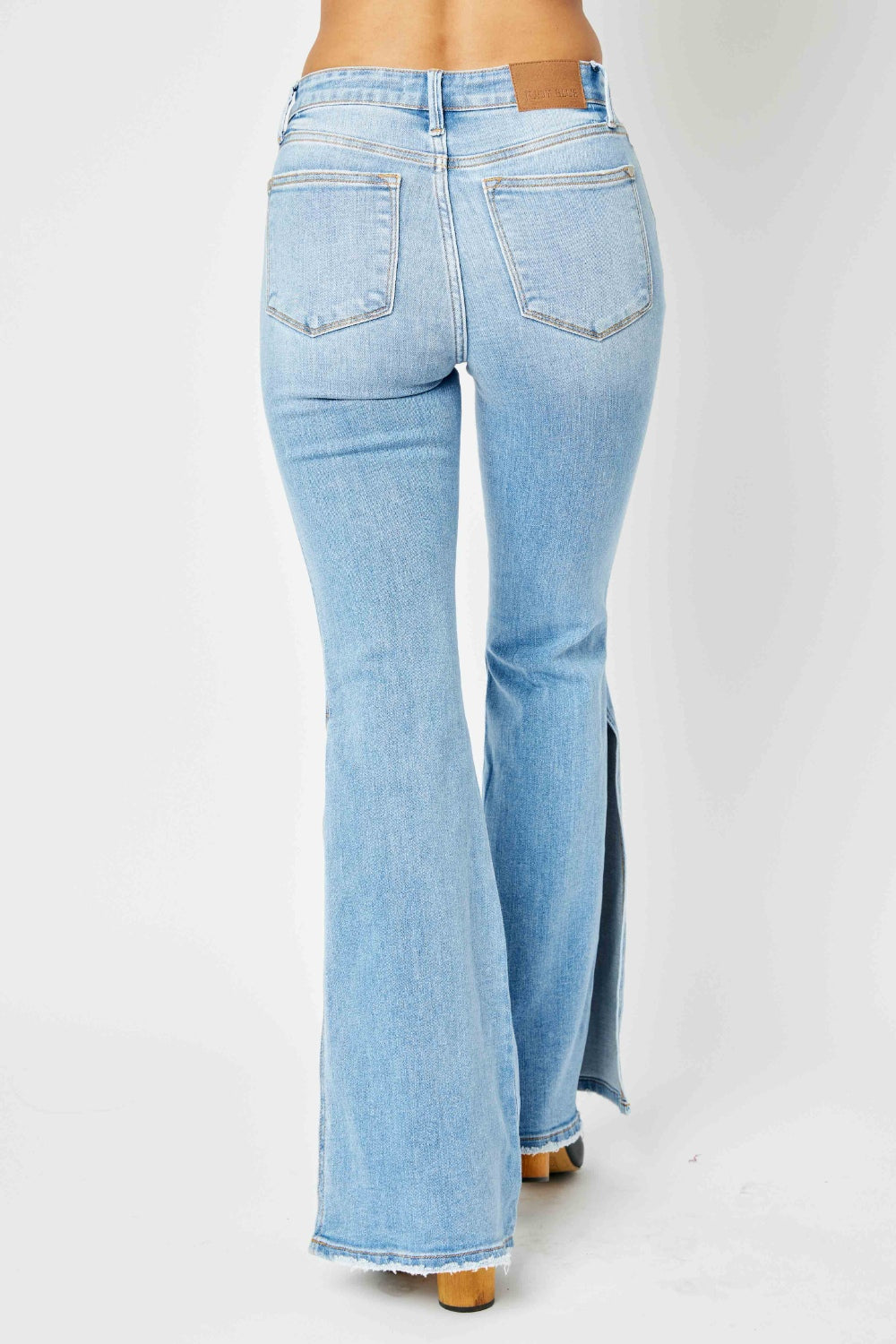 Judy Blue mid rise raw hem slit flare jeans back view