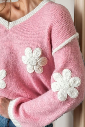 Close-up of pink sweater with white floral design